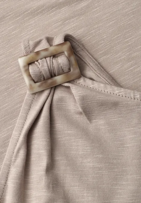 Beige stoftop met decoratieve rechthoekige gesp aan de schouder