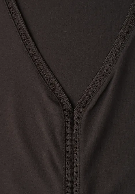 Nahaufnahme eines schwarzen V-Ausschnitt-Oberteils mit feiner Lochverzierung am Kragen.