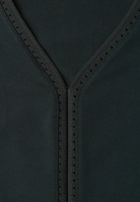 Nahaufnahme eines schwarzen V-Ausschnitts mit Ziernähten und kleinen Perforationen