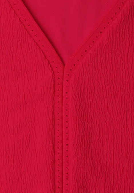 Rote, strukturierte V-Ausschnitt-Bluse aus leichtem Stoff.