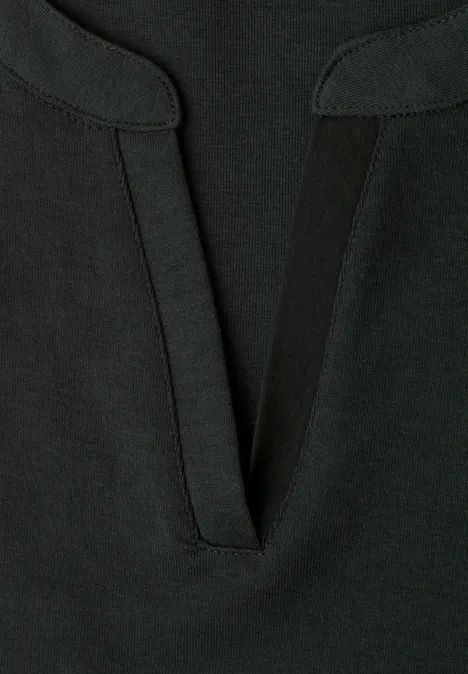 Nahaufnahme eines schwarzen Oberteils mit V-förmigem Ausschnitt und feinem Stoff.