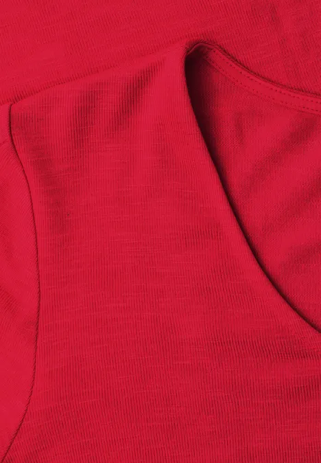 Close-up van een rode mouwloze top met ronde hals en fijne textuur.
