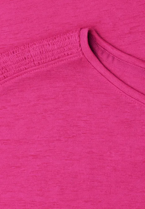 Nahaufnahme eines pinkfarbenen T-Shirts mit Rundhalsausschnitt.