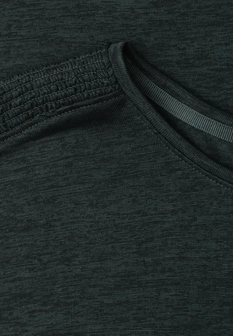 Nahaufnahme eines dunklen Sportshirts mit schrägem Ausschnitt und meliertem Stoff.