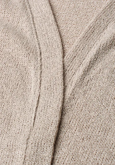 Feine Nahaufnahme eines beigen Strickgewebes mit dezenter Nahtverzierung.