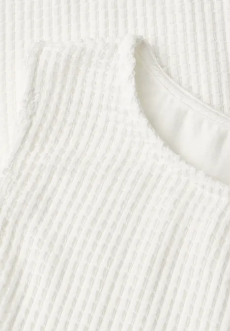 2-in-1 top van mesh met boothals off white Close-up van witte geribbelde stof met ronde halslijn.