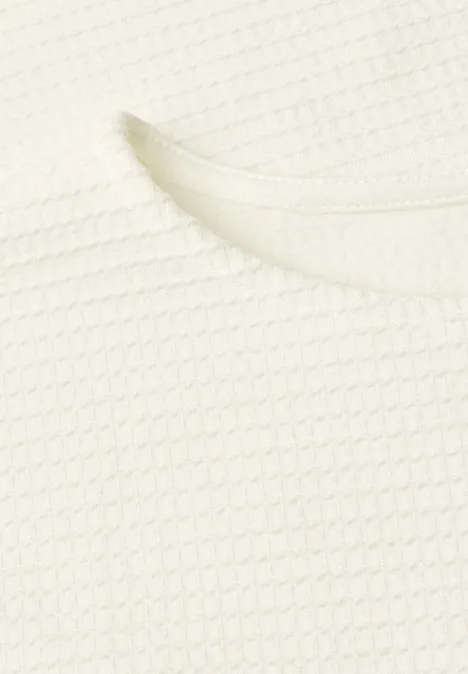 Shirt met structuur in effen kleur off white Close-up van een wit kledingstuk met wafelstructuur en ronde halslijn.