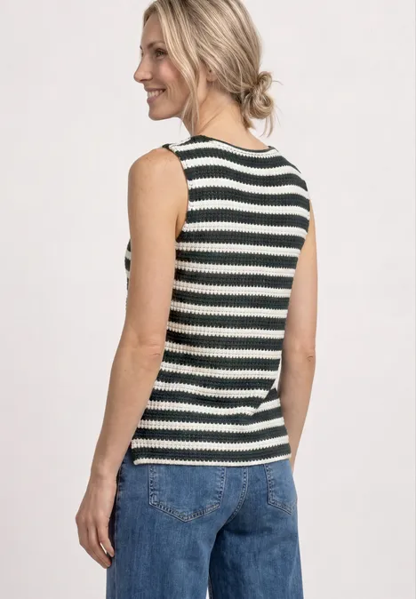 Femme vue de dos portant un top sans manches rayé noir et blanc et un jean bleu.