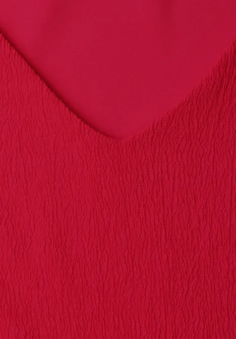 Close-up van rood, gestructureerd textiel met V-vormig patroon