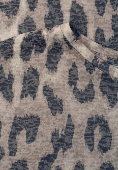 Nahaufnahme eines Stoffes mit unregelmäßigem Leopardenmuster in Grau- und Beigetönen.