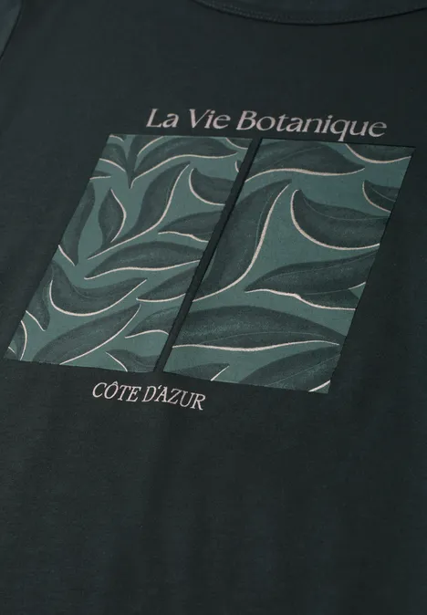Zwart T-shirt met botanische print van groene bladeren en de teksten 'La Vie Botanique' en 'Côte d'Azur'.