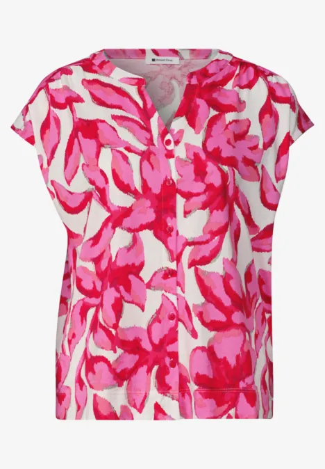 Kurze Damenbluse mit pink-rosa Blumenmuster auf weißem Grund und Rundhalsausschnitt.