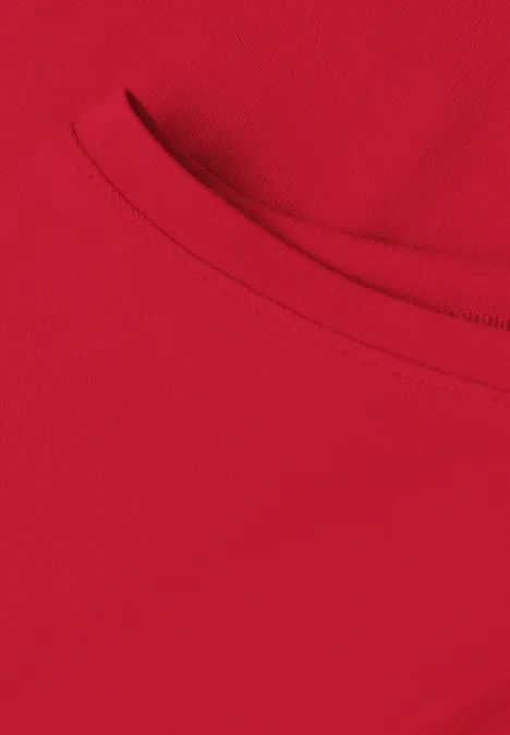 Close-up van een rood T-shirt met ronde hals en zichtbare naad.