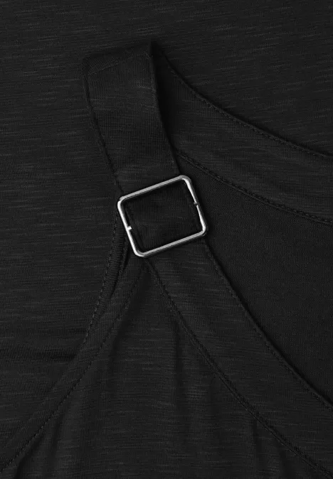 Close-up van zwarte stof met verstelbare band en zilverkleurige metalen gesp.