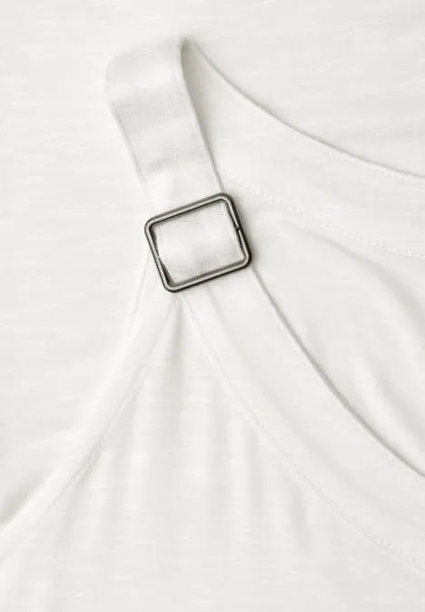 Close-up van een witte band met vierkante metalen verstelgesp aan een kledingstuk