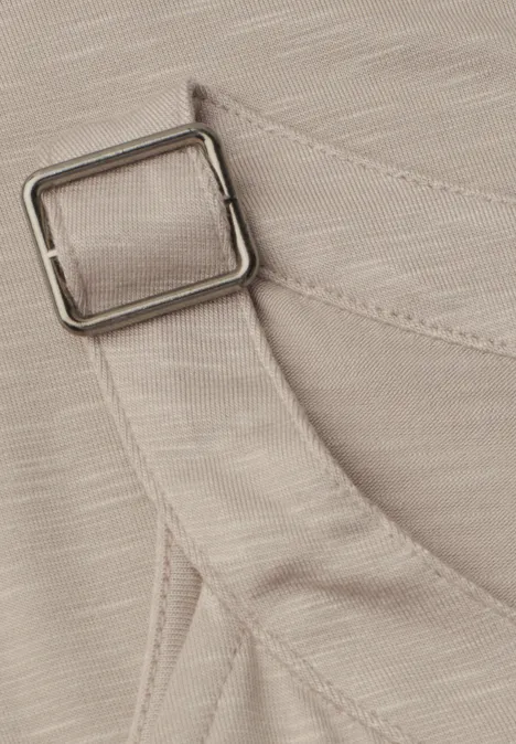 Nahaufnahme eines beigen Stoffbands mit quadratischer Metallschnalle