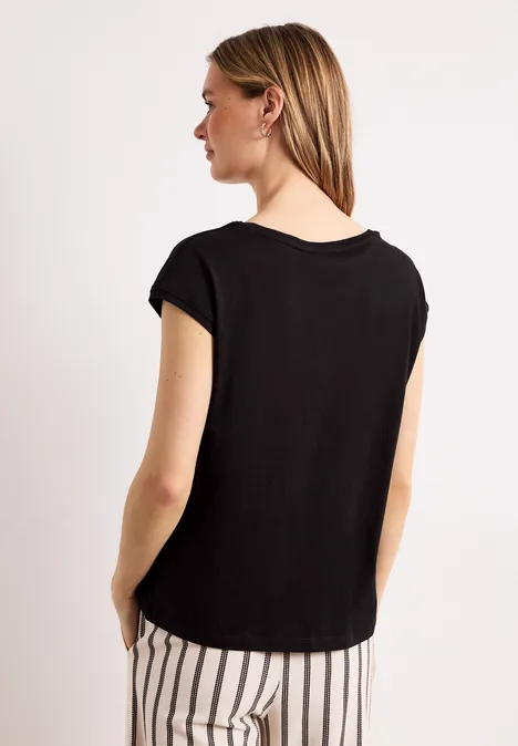 Vrouw van achteren in zwart shirt en zwart-witte gestreepte broek