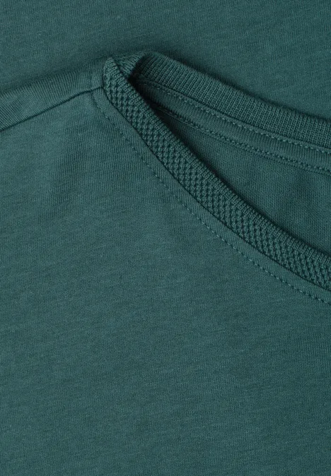 Close-up van een donkergroen T-shirt met zichtbare stiksels bij de ronde hals.