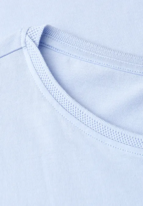 Close-up van de ronde hals van een lichtblauw t-shirt.
