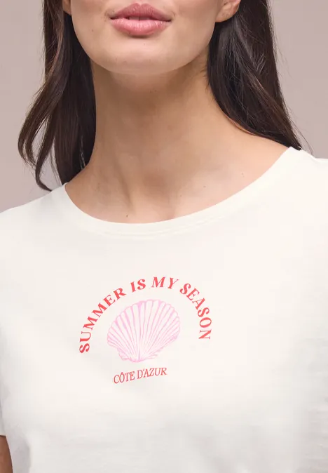 Shirt met schelpenprint off white Close-up van een vrouw in een wit t-shirt met 'SUMMER IS MY SEASON'-tekst en schelpmotief.