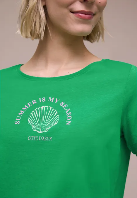 Vrouw met groen T-shirt, schelp en tekst 'SUMMER IS MY SEASON COTE D'AZUR'.
