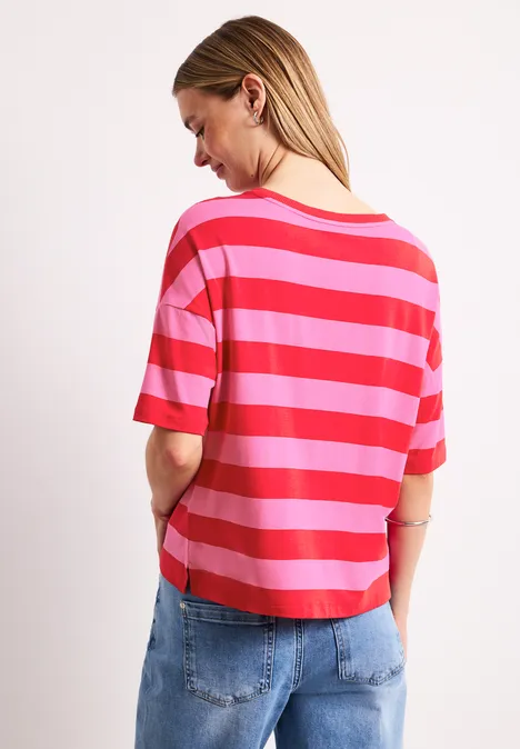 Shirt met ronde hals en strepen salsa red Vrouw van achteren met rood-roze gestreept t-shirt en blauwe jeans voor een witte achtergrond.