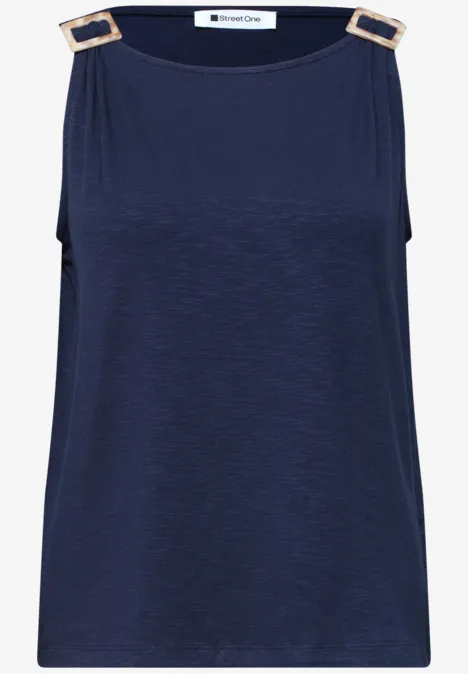 Donkerblauwe mouwloze top met gouden rechthoekige gespen op de schouderbanden.