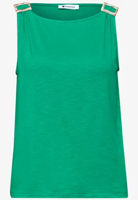 Groen mouwloos topje met gouden gespjes op de schouders.