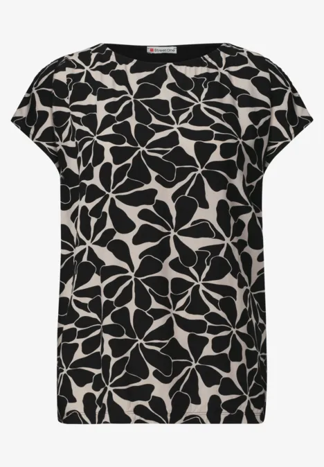 Zwart-witte dames top met korte mouwen en groot bloemenpatroon.