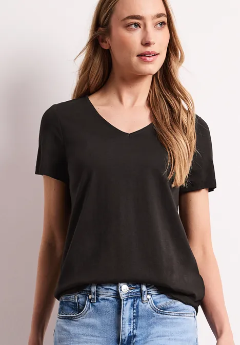 Schlichte schwarze V-Ausschnitt-Shirt mit kurzen Ärmeln, kombiniert mit blauer Jeans.