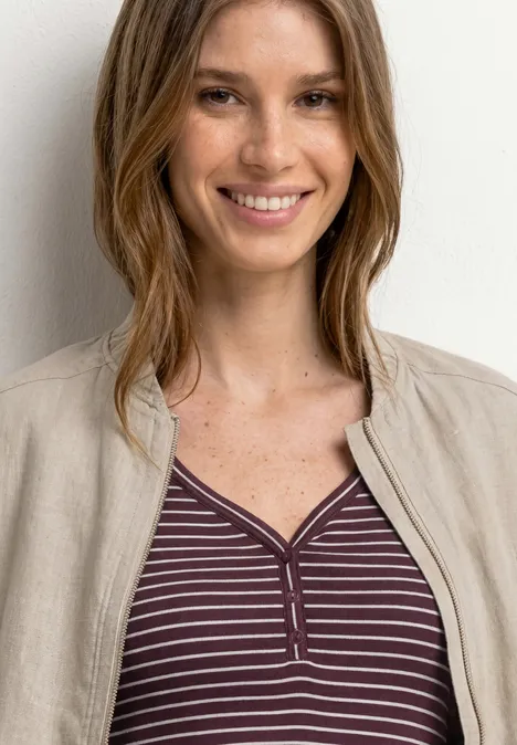 Top mit V-Neck und Streifen rustic rouge Frau mit braunen Haaren trägt gestreiftes lila Shirt und beigen Blazer vor hellem Hintergrund.