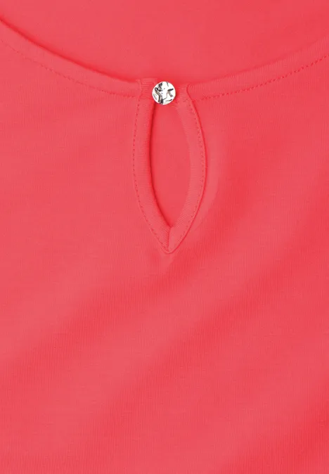 Rotes Oberteil mit kleinem Tropfenausschnitt und rundem Zierknopf