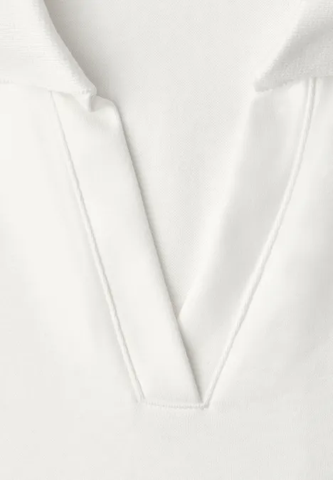 Top in Rippstruktur mit Polokragen off white Nahaufnahme eines weißen V-Ausschnitt-Shirts aus weichem Stoff.