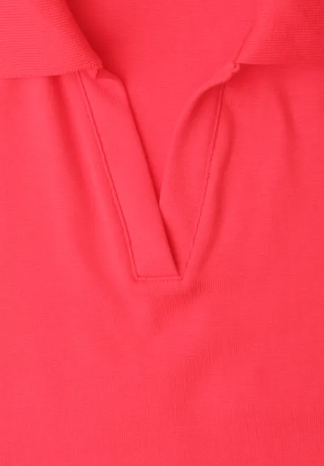 Nahaufnahme eines roten Poloshirts mit V-Ausschnitt.