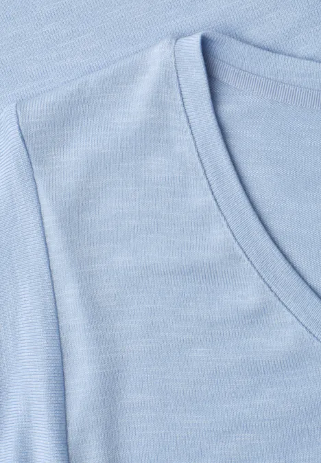 Shirt met korte volantmouwen cashmere blue Close-up van een lichtblauw V-hals T-shirt van zacht materiaal.