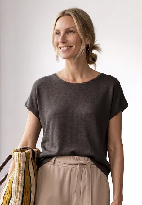 Chemise dropped shoulder à col rond espresso brown Femme portant un t-shirt gris foncé et un sac rayé sur l’épaule, cheveux noués en chignon décontracté.
