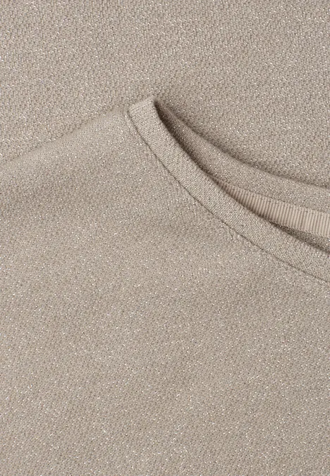 Shirt met overhangende schouders en glitterdetails clay sand Close-up van de beige halslijn van een T-shirt in zachte, gestructureerde stof.