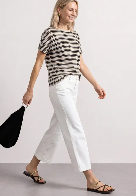 Shirt in Strick-Optik mit Rundhals Black Frau in gestreiftem T-Shirt, weißen Culottes und schwarzen Sandaletten trägt schwarze Tasche.