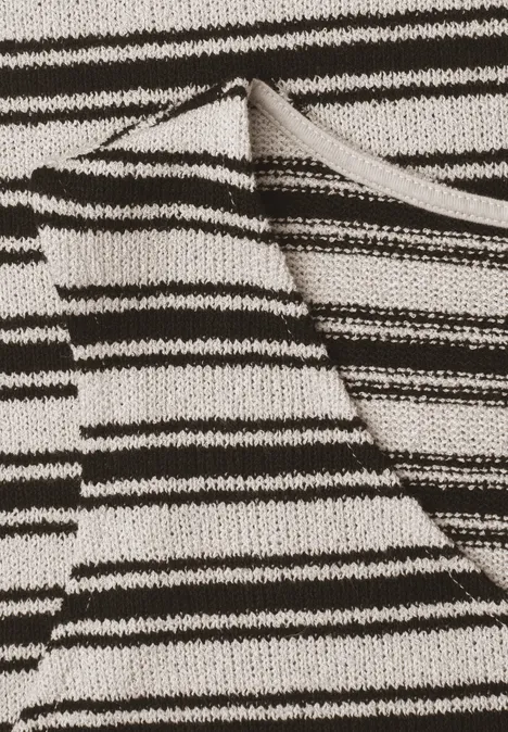 Feines Strickmuster in Schwarz-Weiß mit ungleichmäßigen horizontalen Streifen auf gefaltetem Stoff.