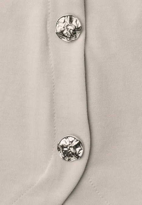 Top mit seitlichen Knopfdetails clay sand Drei silberne Knöpfe an hellbeigem Stoff mit Nahtdetail.