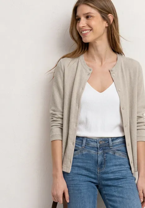 3/4-Arm Jacke in Strick-Optik clay sand Frau in weißem Top, beigem Cardigan und blauen Jeans vor neutralem Hintergrund.