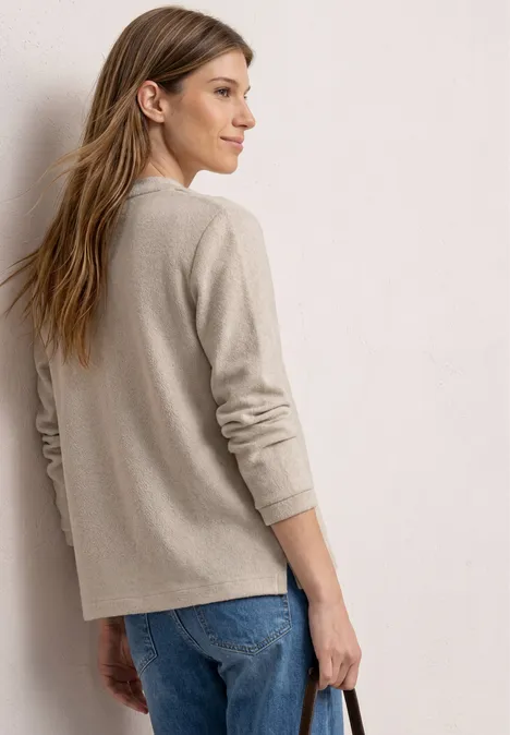 3/4-Arm Jacke in Strick-Optik clay sand Rückansicht einer Frau in beigem Pullover und blauer Jeans vor hellem Hintergrund.