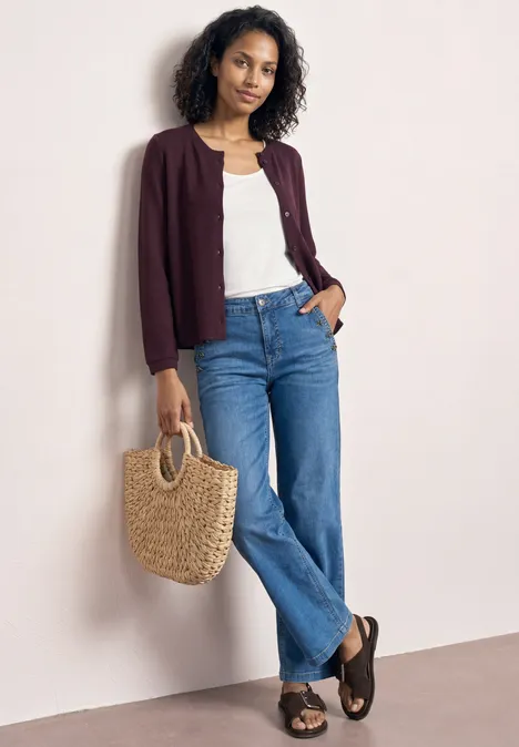 3/4-Arm Jacke in Strick-Optik rustic rouge Eine Person trägt Jeans, weißes Top, bordeauxfarbenen Cardigan, schwarze Sandalen und hält eine Strohtasche.