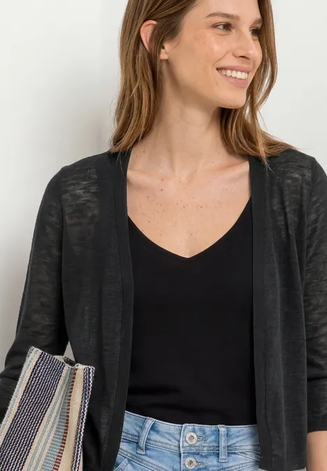 Jack met 3/4 mouwen in een open pasvorm Black Vrouw met een zwarte top, dun vest, lichtblauwe jeans en een gestreepte tas.