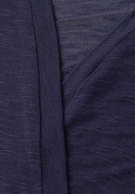 Close-up van een donkerblauwe, fijne tricotstof met overlappende randen.