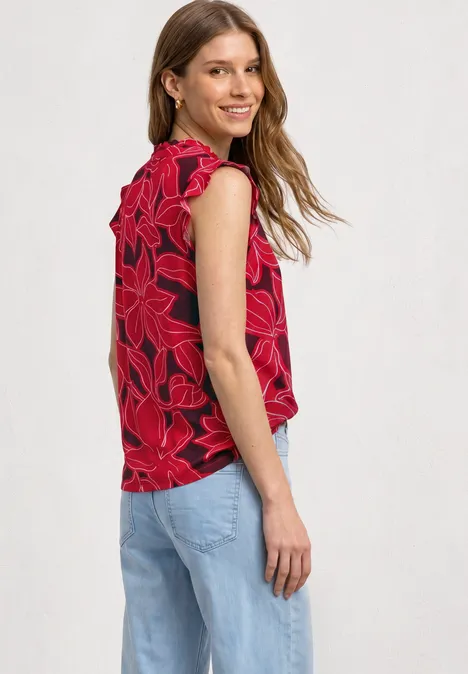 Top mit Strukturmix und Crochet-Details salsa red Eine seitlich stehende Frau trägt ein rotes, ärmelloses Top mit Blumenmuster und eine hellblaue Jeans.