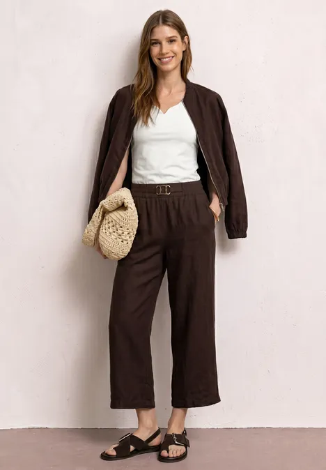 Basic Top mit Herzausschnitt off white Frau in braunem Oversize-Blazer und Culotte, weißem Top, schwarzen Sandalen und geflochtener Tasche