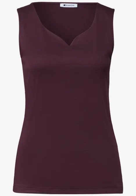 Top sans manches bordeaux, cintré, avec un décolleté légèrement asymétrique.