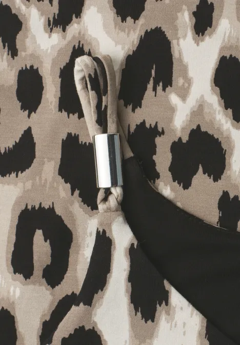 Top mit V-Neck und Deko-Detail timeless beige Nahaufnahme eines Leopardenmusters neben schwarzem Stoff und einer silbernen Metallschnalle an einem Textilband.