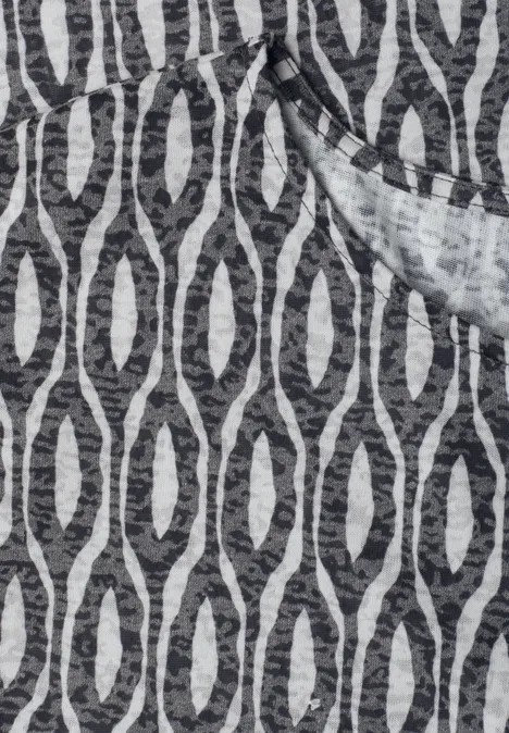 Tissu gris chiné avec motifs ovales noirs entrelacés.